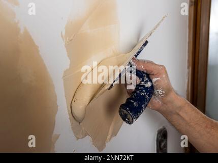 Nahaufnahme von männlichen Händepflasterungen im Hausrenovierungsprozess Stockfoto