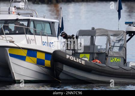 Greenock, Schottland, Großbritannien. 25. Februar 2023 Polizei und Pilot am Ort des Untergangs des Clyde Marine Services Tubs Biter, der gestern in Greenock in der Nähe des Ost-Indien-Hafens gesunken ist. Zwei Crewmitglieder werden immer noch vermisst. Bild: Polizeitaucher arbeiten über dem versunkenen Schlepper. Iain Masterton/Alamy Live News Stockfoto