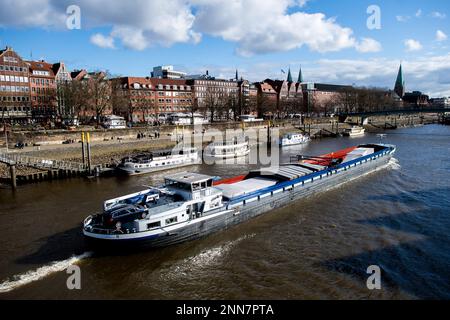 Bremen, Deutschland. 25. Februar 2023. Bei sonnigem Wetter fährt ein Lastkahn auf der Weser vorbei an der Schlachte und der Altstadt. Kredit: Hauke-Christian Dittrich/dpa/Alamy Live News Stockfoto