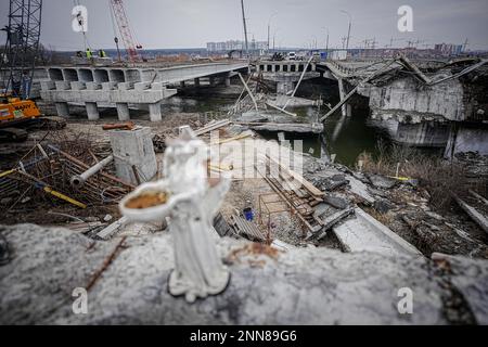 Irpin, Ukraine. 25. Februar 2023. Ein gebrochener Engel steht auf der Brücke, die während des Krieges zerstört wurde, auf der arteriellen Straße von Irpin bei Kiew. Die Brücke ist in vollem Gange. Kredit: Kay Nietfeld/dpa/Alamy Live News Stockfoto