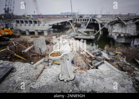 Irpin, Ukraine. 25. Februar 2023. Ein gebrochener Engel steht auf der Brücke, die während des Krieges zerstört wurde, auf der arteriellen Straße von Irpin bei Kiew. Die Brücke ist in vollem Gange. Kredit: Kay Nietfeld/dpa/Alamy Live News Stockfoto