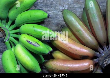 Eine Gruppe frischer, reifer Bananen in Grün- und Brauntönen, kunstvoll in einem Stapel angeordnet Stockfoto
