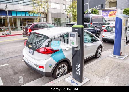 Die Elektroautos des BlueLA Blink Mobilitätssystems parken an einem Car-Sharing-Platz in einer belebten Straße in Los Angeles Stockfoto