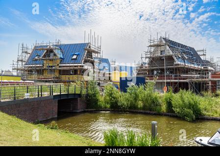 Einfamilienhäuser im Bau in einem Wohnungsbau auf dem Lande der Niederlande an einem sonnigen Sommertag Stockfoto