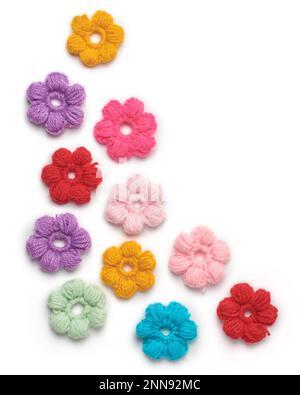 Abstraktes Wollgestrickmaterial, Muster bunter gewebter Garnblumen isoliert auf weißem Hintergrund, Strick- und Bastelkonzept Stockfoto