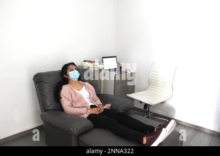 Lateinische Frau mit Schutzmaske in medizinischen Tests, Elektroenzephalogramm und Hirnkartierung in Zeiten der Covid-19-Kontingenz Stockfoto