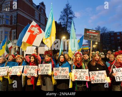 Ansicht von Demonstranten mit Spruchbändern in einer Kerzenwache im russischen Konsulat in London zum ersten Jahrestag der russischen Invasion in der Ukraine Stockfoto