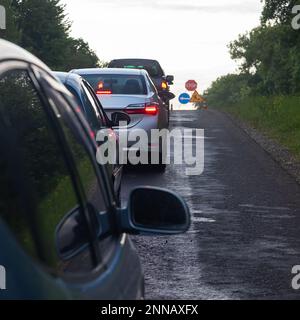 Verkehrsstaus auf der Straße sind mit der Reparatur der Straße verbunden. Guten Abend Stockfoto