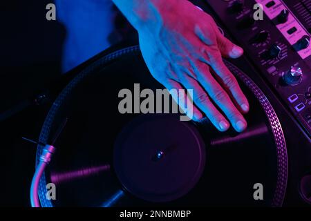 Hip-Hop-dj kratzt Schallplatte auf Party im Nachtclub. Overhead-Foto von Discjockey-Mischplatten Stockfoto