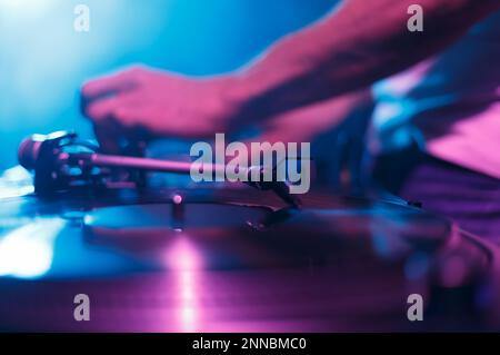 Club-DJ-Musik mit Schallplatten und Drehtisch. Discjockey mixt Musiktitel auf einer Party im Nachtclub, konzentriert euch auf die Nadel der Drehscheiben Stockfoto