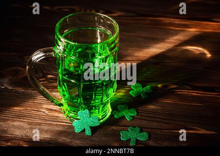 Feiern Sie St. Patricks Tag. Gläser Green Beer Pint auf einer hölzernen Theke, dekoriert mit Shamrock-Blättern. 17 Birke. Traditionelles Getränk im li Stockfoto