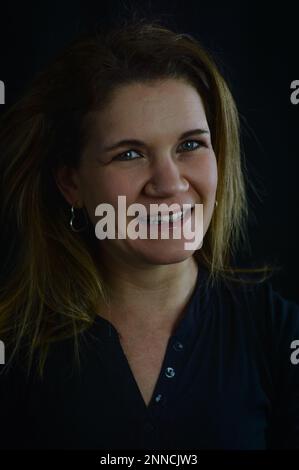 Porträt einer schönen blonden Frau, die spontan und ehrlich fröhlich lächelt Stockfoto