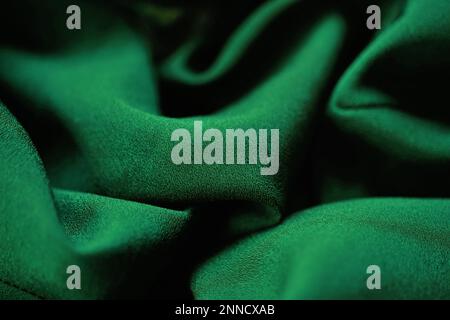 Zartes dunkelgrünes Material, grüne Chiffonwellen. Stockfoto