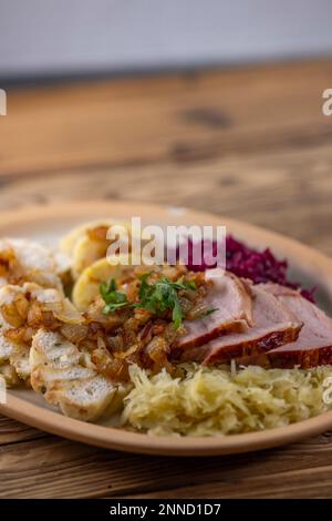 Geräuchertes Fleisch, serviert mit Rot- und Weißkohl und zwei Sorten Knödel Stockfoto