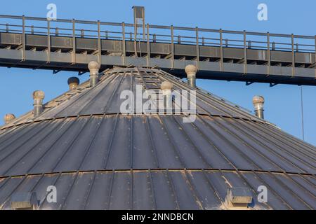 Eine große moderne Pflanze für die Lagerung und Verarbeitung von Getreidepflanzen. Blick auf die Kornkammer an einem sonnigen Tag. Große Eisenfässer mit Getreide. Silbersilos auf A Stockfoto