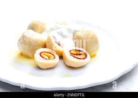 Pflaumenknödel mit Sauerrahm, Puderzucker und geschmolzener Butter Stockfoto