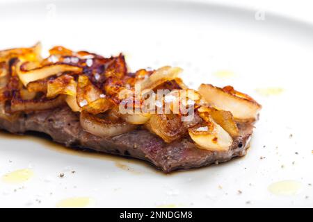 Steak mit karamellisierten Zwiebeln bedeckt Stockfoto