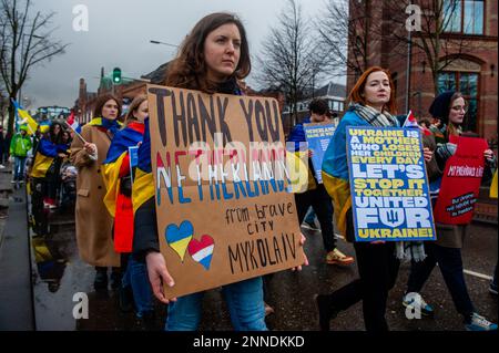 Eine ukrainische Frau hält ein Plakat, das den Niederlanden für ihre Unterstützung während der Demonstration dankt. In Amsterdam Tausende ukrainische Menschen und Anhänger gingen vom Museumplein zum Dam-Platz, um die niederländische Gesellschaft daran zu erinnern, dass der Krieg weitergeht und dass mutige ukrainische Menschen ihr Land verteidigen und dass die Ukraine damit Unterstützung braucht.denn Freitag, der 24. Februar, ist ein Jahr, seit Russland seine Existenz begonnen hat Krieg gegen die Ukraine, mehrere Demonstrationen sind in den Niederlanden geplant. Mehr als acht Millionen Menschen wurden gezwungen, die Ukraine zu verlassen, und weitere Stockfoto