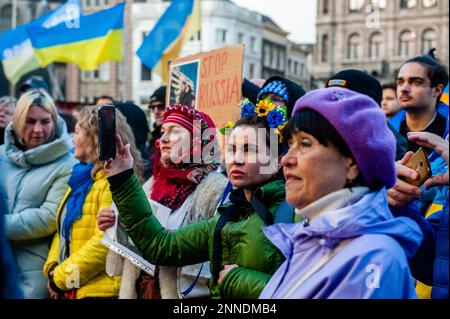 Man sieht, wie das ukrainische Volk während der Demonstration Reden zur Unterstützung seines Landes hört. In Amsterdam Tausende ukrainische Menschen und Anhänger gingen vom Museumplein zum Dam-Platz, um die niederländische Gesellschaft daran zu erinnern, dass der Krieg weitergeht und dass mutige ukrainische Menschen ihr Land verteidigen und dass die Ukraine damit Unterstützung braucht.denn Freitag, der 24. Februar, ist ein Jahr, seit Russland seine Existenz begonnen hat Krieg gegen die Ukraine, mehrere Demonstrationen sind in den Niederlanden geplant. Mehr als acht Millionen Menschen wurden gezwungen, die Ukraine zu verlassen, und weitere fünf Millionen haben dies getan Stockfoto