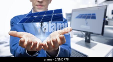 Der Entwicklungsingenieur hält ein Modell eines Solarmoduls in der erweiterten Realität in seinen Händen. Stockfoto