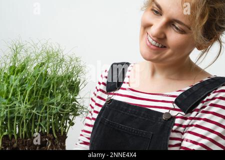 Eine Frau hält ein Mikrogrün in den Händen. Nahaufnahme. Stockfoto