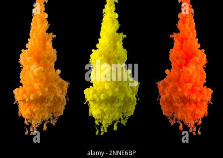 Gelbe, orangefarbene Farbwolken in Wasser, isoliert auf festem schwarzem Hintergrund. Acrylfarben und Tinte in Wasser. Abstrakter Hintergrund. Bunte Kunst. Stockfoto