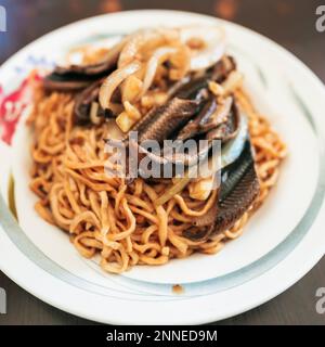 Taiwanesisches Street Food - Aalnudeln. Es ist gebratener Aal, serviert auf flachen Nudeln in einer dicken, süßen und sauren Sauce. Stockfoto