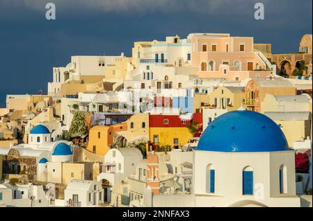 Europa, Griechenland, Santorin, Oia. Blick auf die bunten Häuser auf dem Hügel auf Santorini. Stockfoto