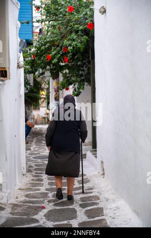 Europa, Griechenland, Santorin, Oia. Eine Frau geht in Griechenland durch eine enge Gasse. "Nur Redaktionelle Verwendung." Stockfoto