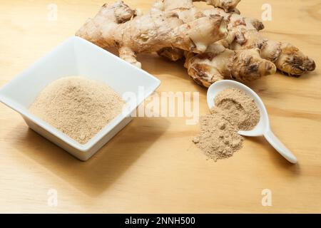 Frische Wurzeln und Ingwerpulver - Zingiber officinale; Foto auf Holzhintergrund. Stockfoto