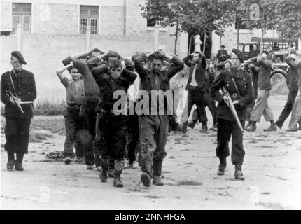 Französische miliz (in Uniform mit Waffen) eskortiert Widerstandshäftlinge im Juli 1944. Die Miliz war die französische Vichy-Miliz (d. h. Kollaborateure mit dem nazi-Regime). Photo Bundesarchiv, Bild 146-1989-107-24/Koll/CC-BY-SA 3,0, CC BY-SA 3,0 de, https://commons.wikimedia.org/w/index.php?curid=5419501 Stockfoto