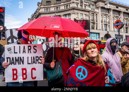 Mann mit dem BBC-Plakat „Lügner, verdammte Lügner“ und der russischen Flagge auf seinem Kopf und Frau mit Friedenszeichen, Kampagne für nukleare Abrüstung (CND) und Stopp Stockfoto