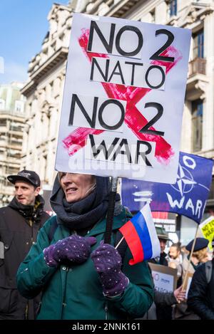 Frau mit russischer Flagge und russischem Plakat "No 2 NATO, No2 war", Kampagne für nukleare Abrüstung (CND) und Demonstration der Kriegskoalition stoppen Stockfoto