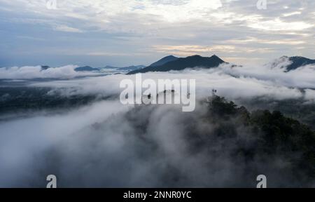 Luftaufnahme Drohne fliegen über das Meer des Nebels, schwimmendes Meer aus Wolken wie Wolkenwellen auf Bergen, Himmel und Wolken. Blick auf den Berg voller Nebel im m Stockfoto