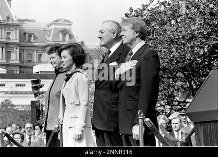 Von links nach rechts: Frau James (Audrey) Callaghan, First Lady Rosalynn Carter, Premierminister James Callaghan des Vereinigten Königreichs Großbritannien und Nordirland, Und US-Präsident Jimmy Carter, sehen Sie sich die Nationalhymne an, die während der offiziellen Ankunftszeremonie zu Ehren von PM und Mrs. Callaghan am 10. März 1977Credit aufgeführt wird: Benjamin E. 'Gene' Forte / CNP / MediaPunch Stockfoto