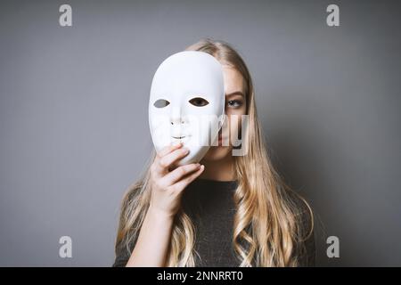 Jugendlich Mädchen ihr Gesicht verstecken sich hinter Masken - Identität oder Persönlichkeit Konzept Stockfoto