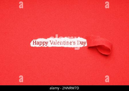 Happy Valentines Tag gruss Text durch die Bohrung in der rotes Papier Hintergrund Rip gesehen Stockfoto