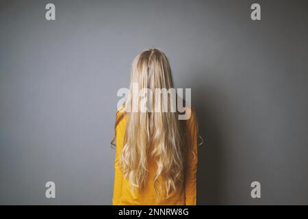 Deprimiert junge Frau ihr Gesicht verstecken hinter lange blonde Haare, schüchtern oder gleichgültig Jugendmädchen Stockfoto