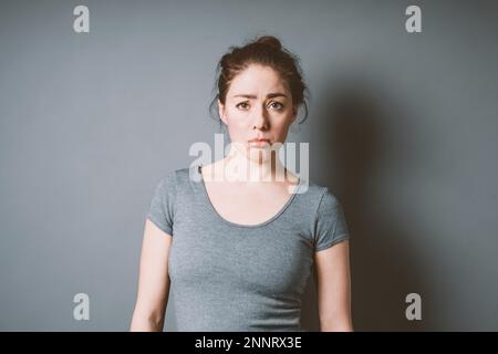 Sulky schmollen, junge Frau in ihrem 20s Gefühl letdown und Enttäuschung - negative Emotionen schlechte Laune Konzept mit Kopie Raum Stockfoto