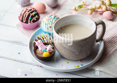 Eine Tasse heiße Mandelmilch serviert mit hausgemachten Kakaobomben zu Ostern. Stockfoto