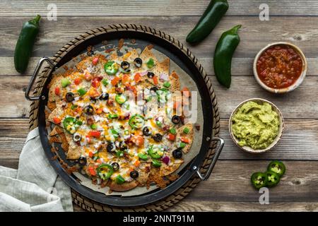 Hausgemachte Keto-Tortilla-Chips in Nachos, serviert mit Salsa und Guacamole. Stockfoto