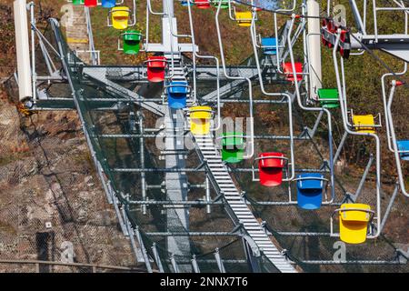 Seilbahnsitze über dem Berg. Leerer Sessellift draußen Stockfoto