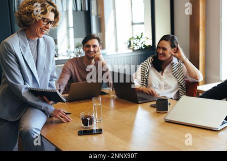 Technische Designer treffen sich mit ihrem Manager in einem Büro. Team von Geschäftsleuten, die ein Projekt in einem Vorstandssaal diskutieren. Eine Gruppe glücklicher Profis Stockfoto