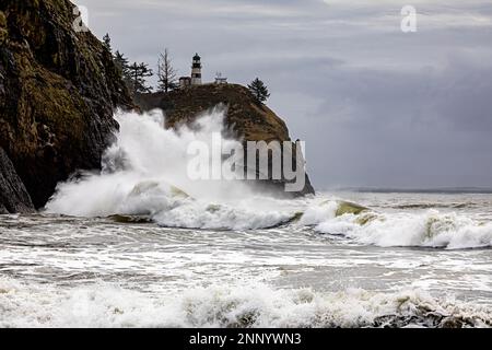 WA23106-00...WASHINGTON - Wellen, die auf den Klippen unter dem Cape Disappointment Lighthouse während einer King Tide; Cape Disappointment State Park krachen. Stockfoto