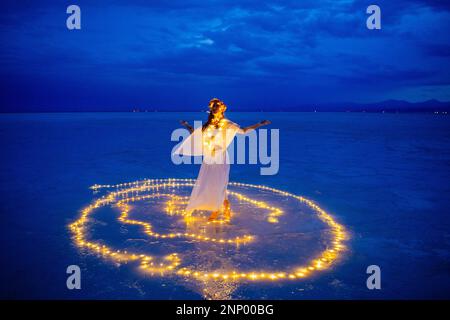 Eine Tänzerin, umgeben von einem Lichtkreis auf dem Wasser Stockfoto