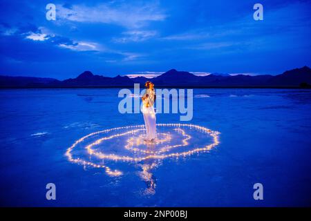 Eine Tänzerin, umgeben von einem Lichtkreis auf dem Wasser Stockfoto