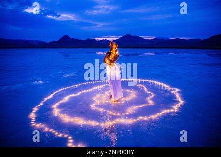 Eine Tänzerin, umgeben von einem Lichtkreis auf dem Wasser Stockfoto