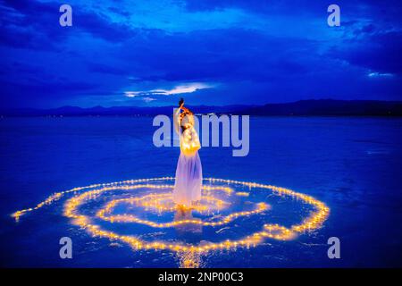 Eine Tänzerin, umgeben von einem Lichtkreis auf dem Wasser Stockfoto