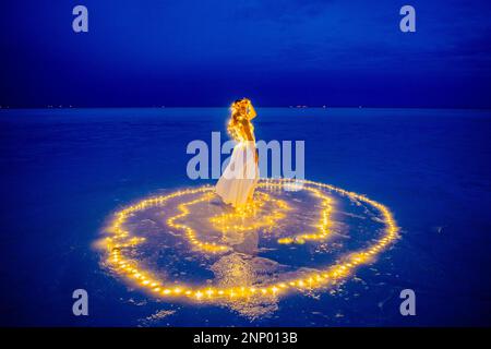 Eine Tänzerin, umgeben von einem Lichtkreis auf dem Wasser Stockfoto