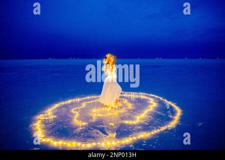 Eine Tänzerin, umgeben von einem Lichtkreis auf dem Wasser Stockfoto